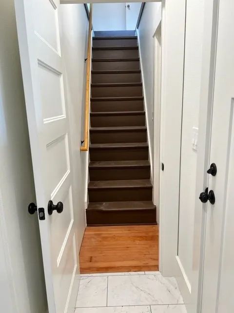 A hallway with stairs leading up to the second floor of a house.