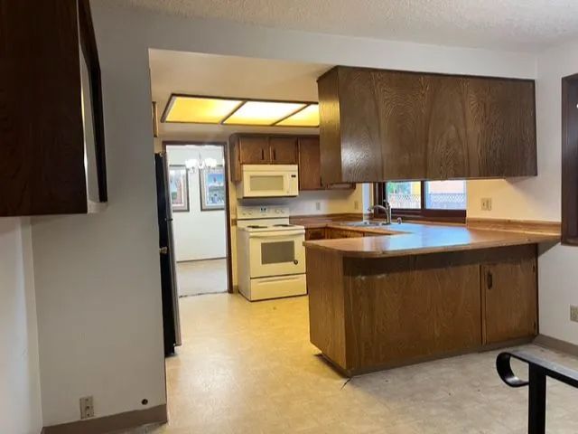 A kitchen with wooden cabinets and a white stove