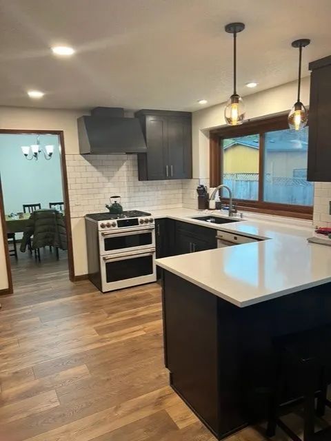 A kitchen with a stove, sink, and a large island.