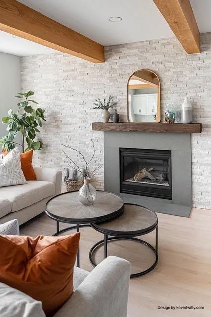 A living room with a fireplace, two coffee tables, a couch, and a mirror.