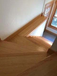 A wooden staircase leading up to a window in a house.