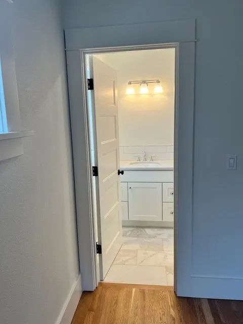 A bathroom with a sink and a door leading to it.