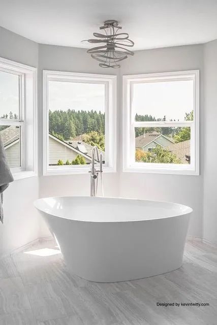 A bathroom with a bathtub and two windows.
