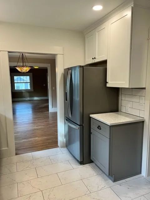 A kitchen with stainless steel appliances and white cabinets.