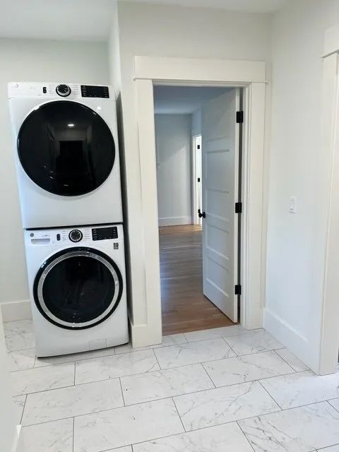 A washer and dryer are stacked on top of each other in a laundry room.