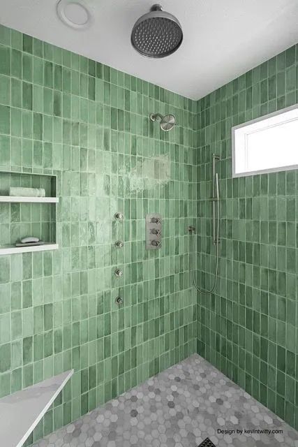 A shower with green tiles and a black shower head.