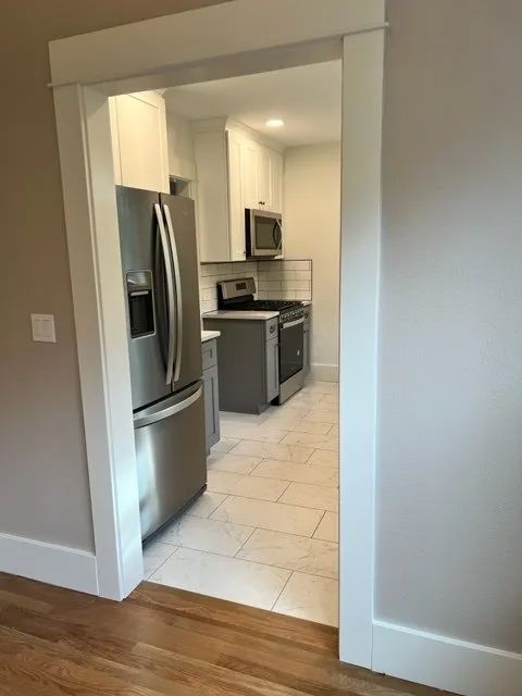 A kitchen with a refrigerator, stove, microwave and dishwasher.