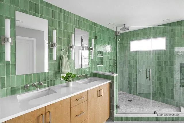 A bathroom with green tiles and a walk in shower.
