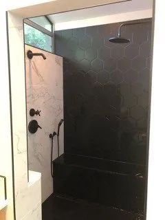 A bathroom with a walk in shower and a sink.