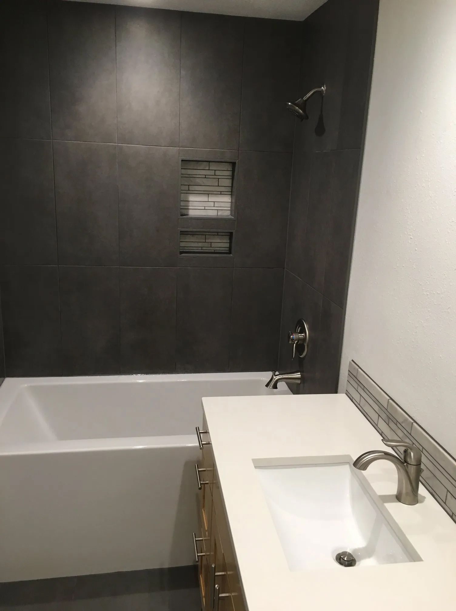 A bathroom with a bathtub, sink and shower.