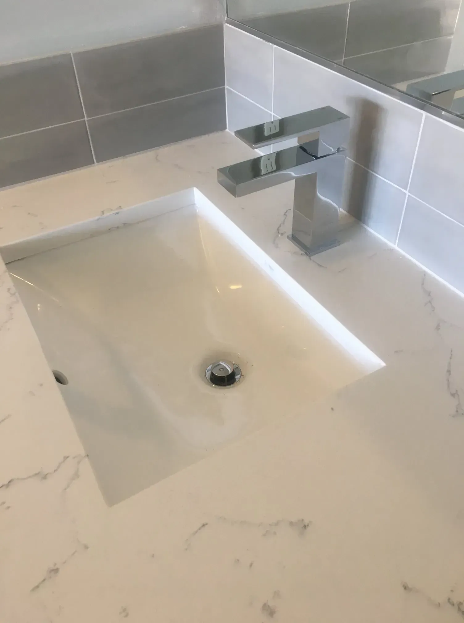 A bathroom sink with a faucet and a mirror.