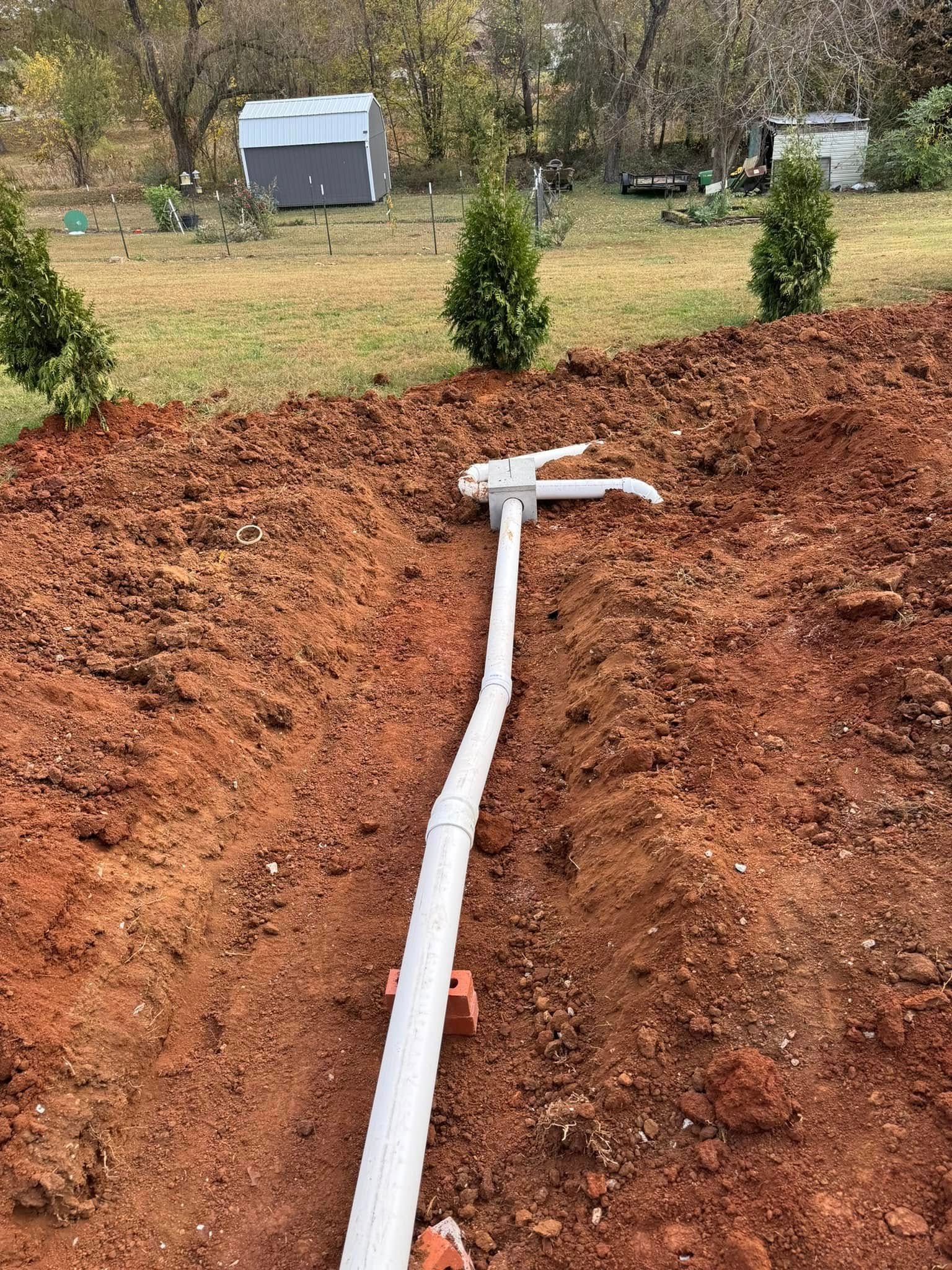 A white pipe is sitting in the middle of a pile of dirt.