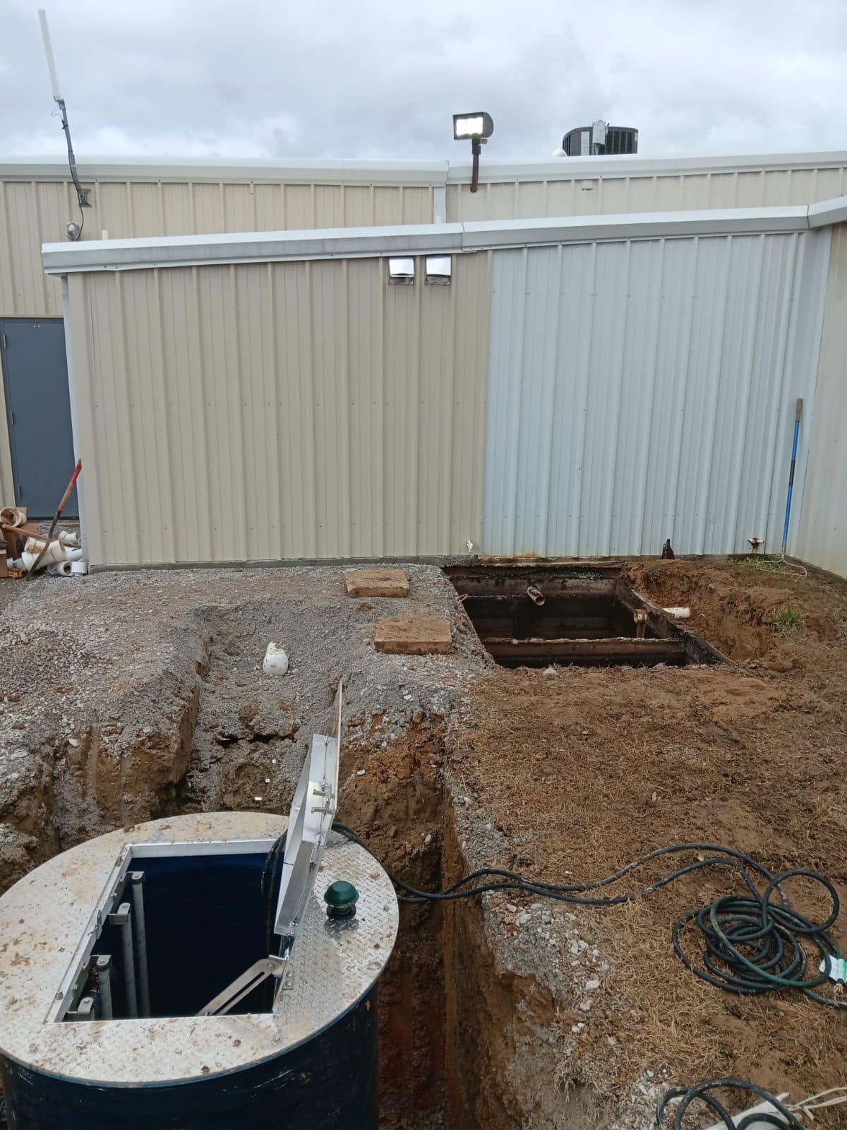 A septic tank is being installed in front of a building.
