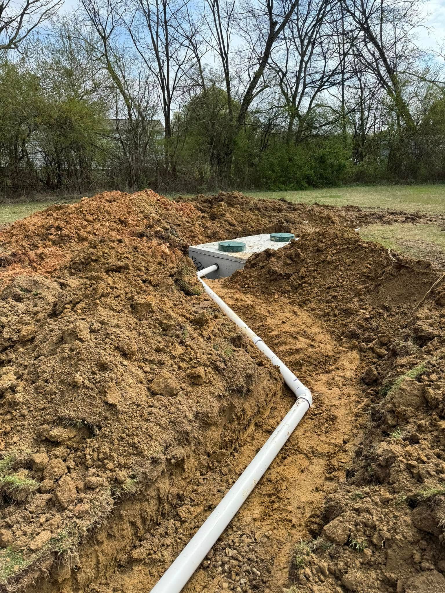 A white pipe is going through a pile of dirt.