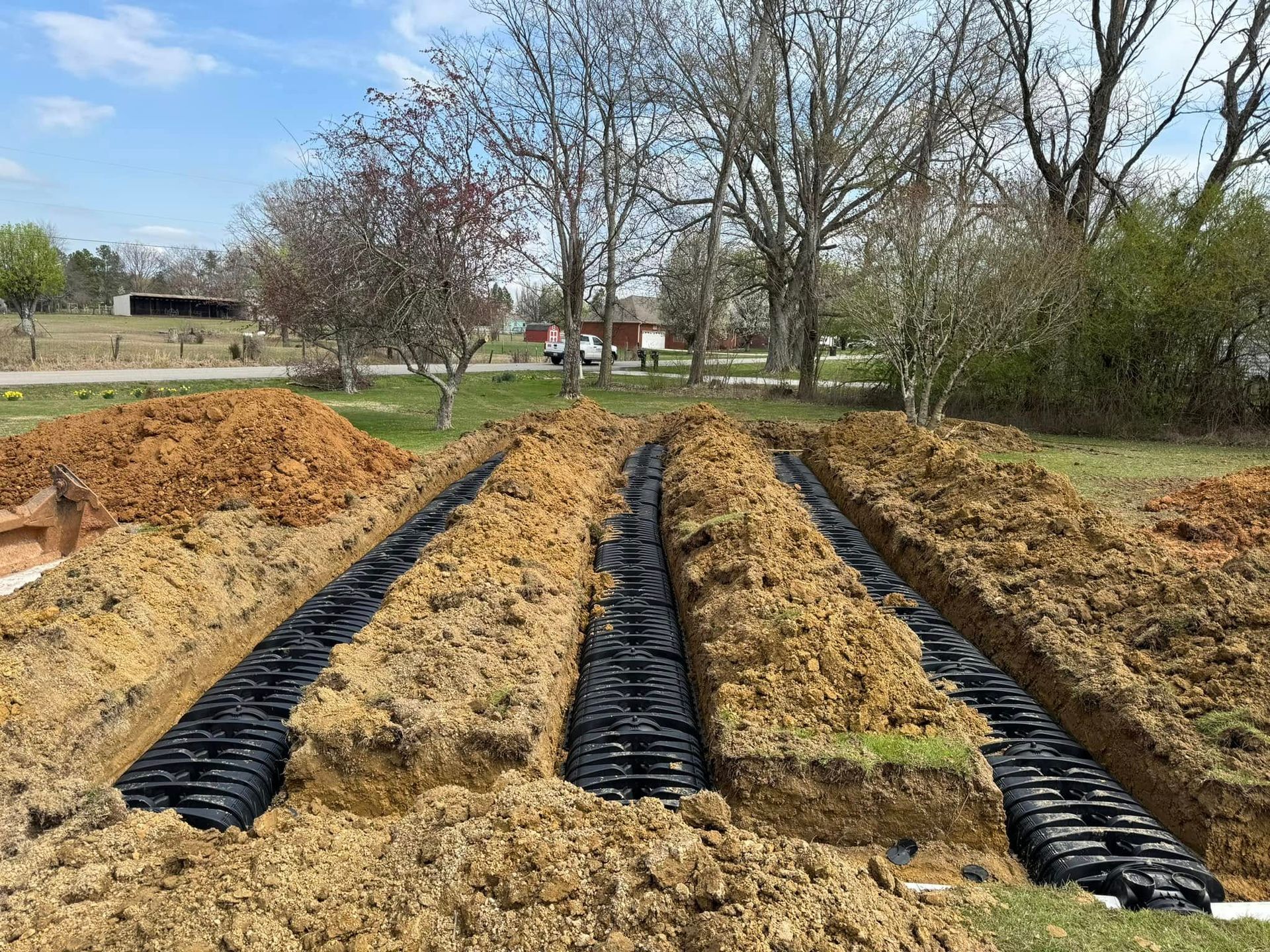 A septic system is being installed in a dirt field.