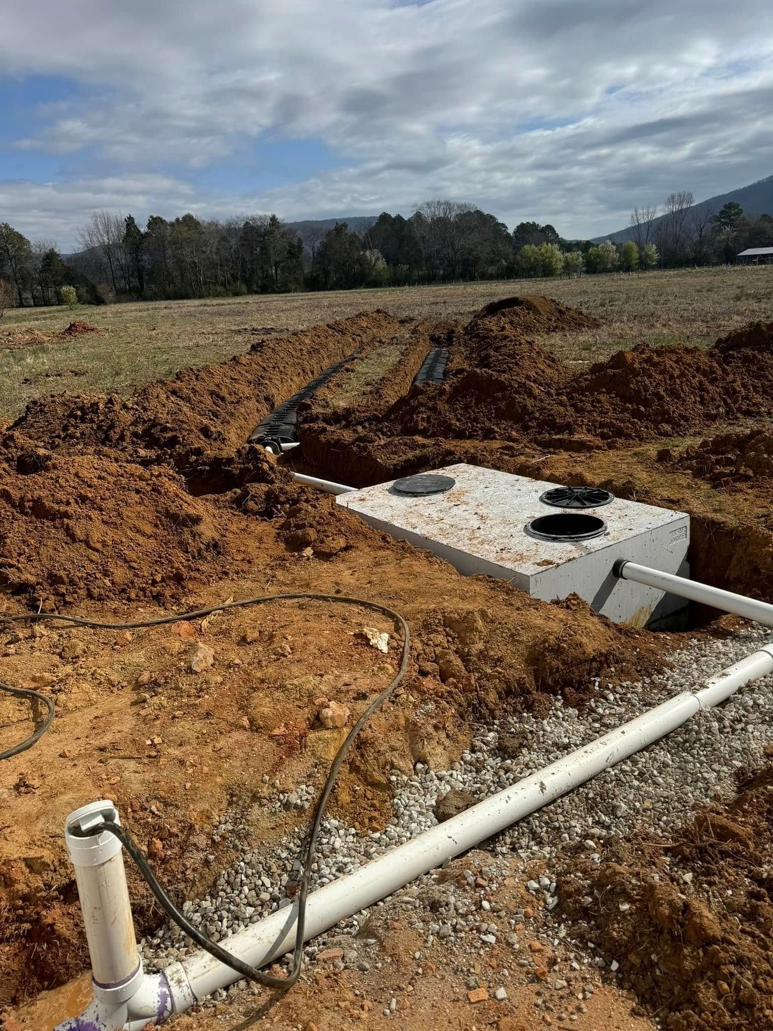 A septic tank is being installed in a dirt field.