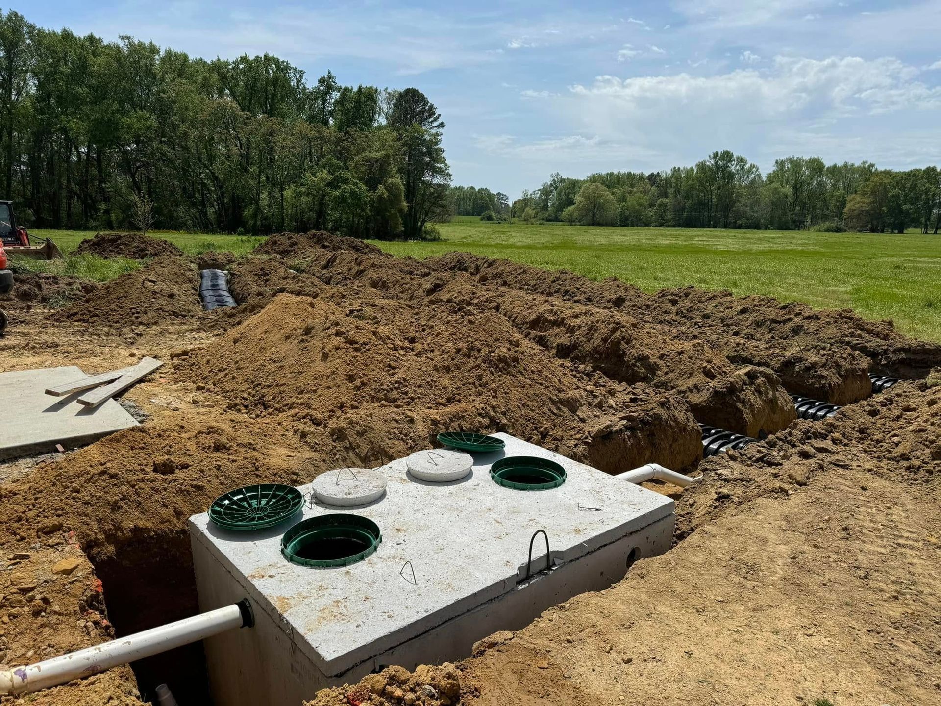 A septic tank is sitting in the middle of a dirt field.