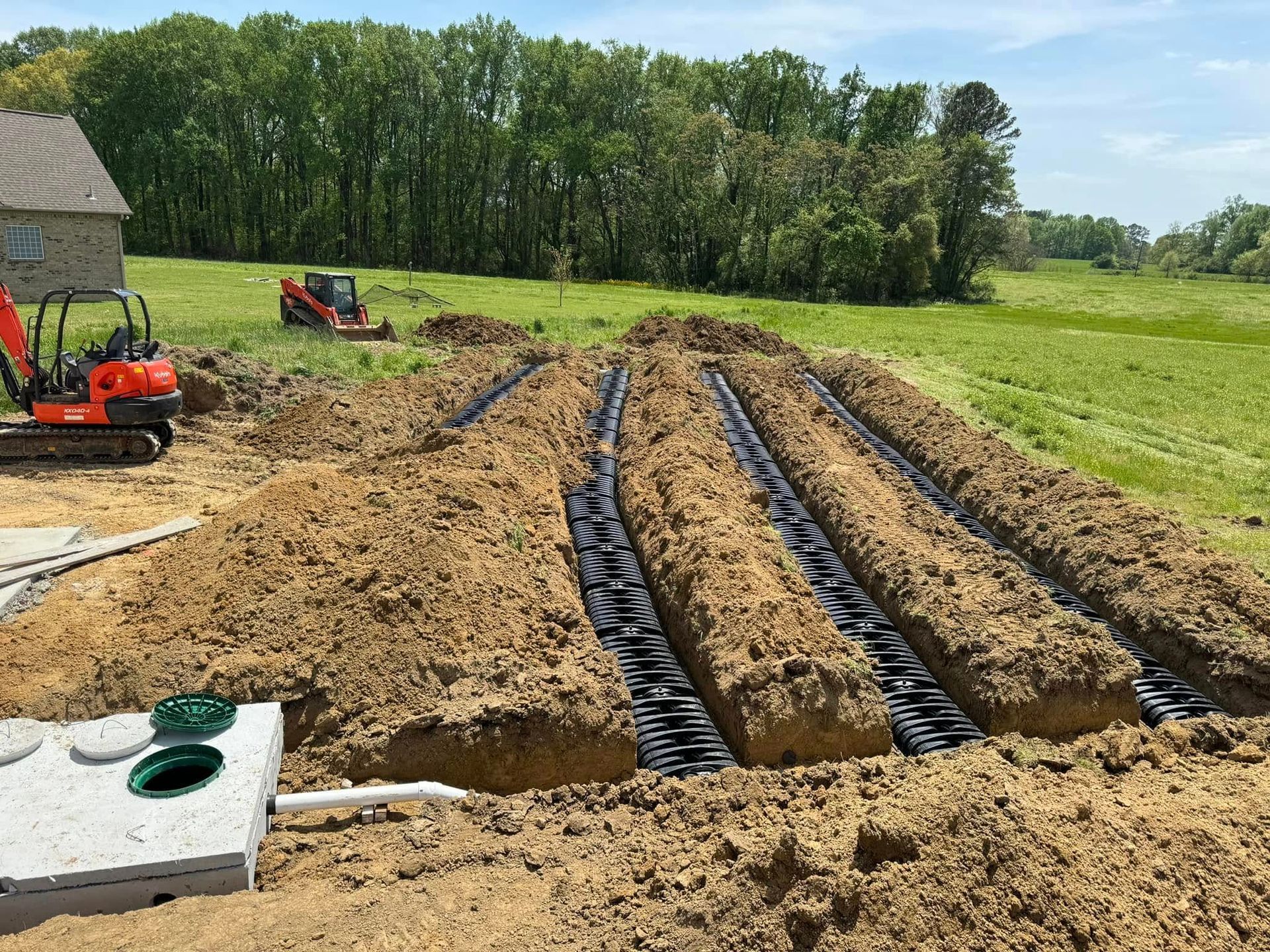 A septic system is being installed in a field.