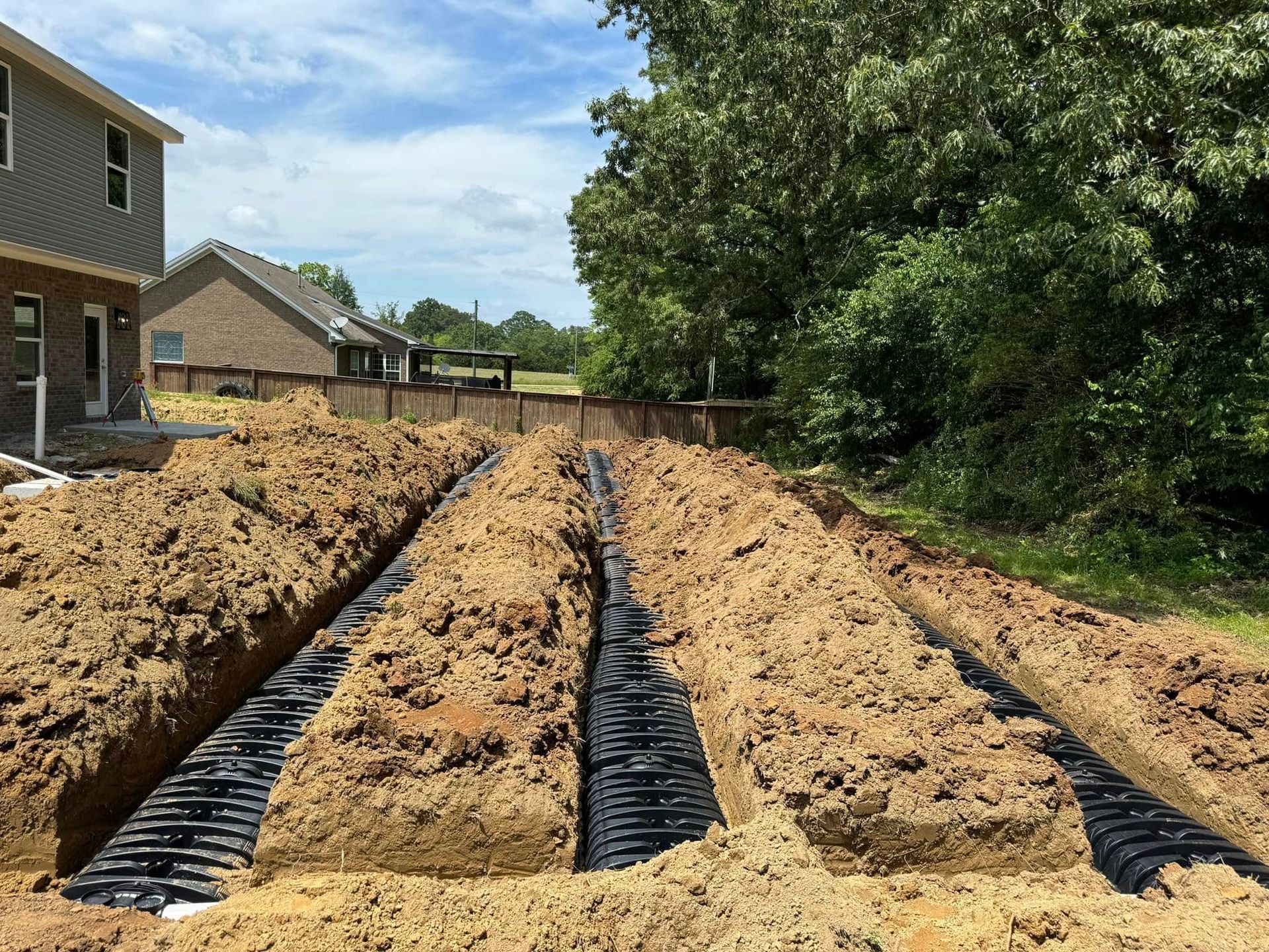 A septic system is being installed in the backyard of a house.