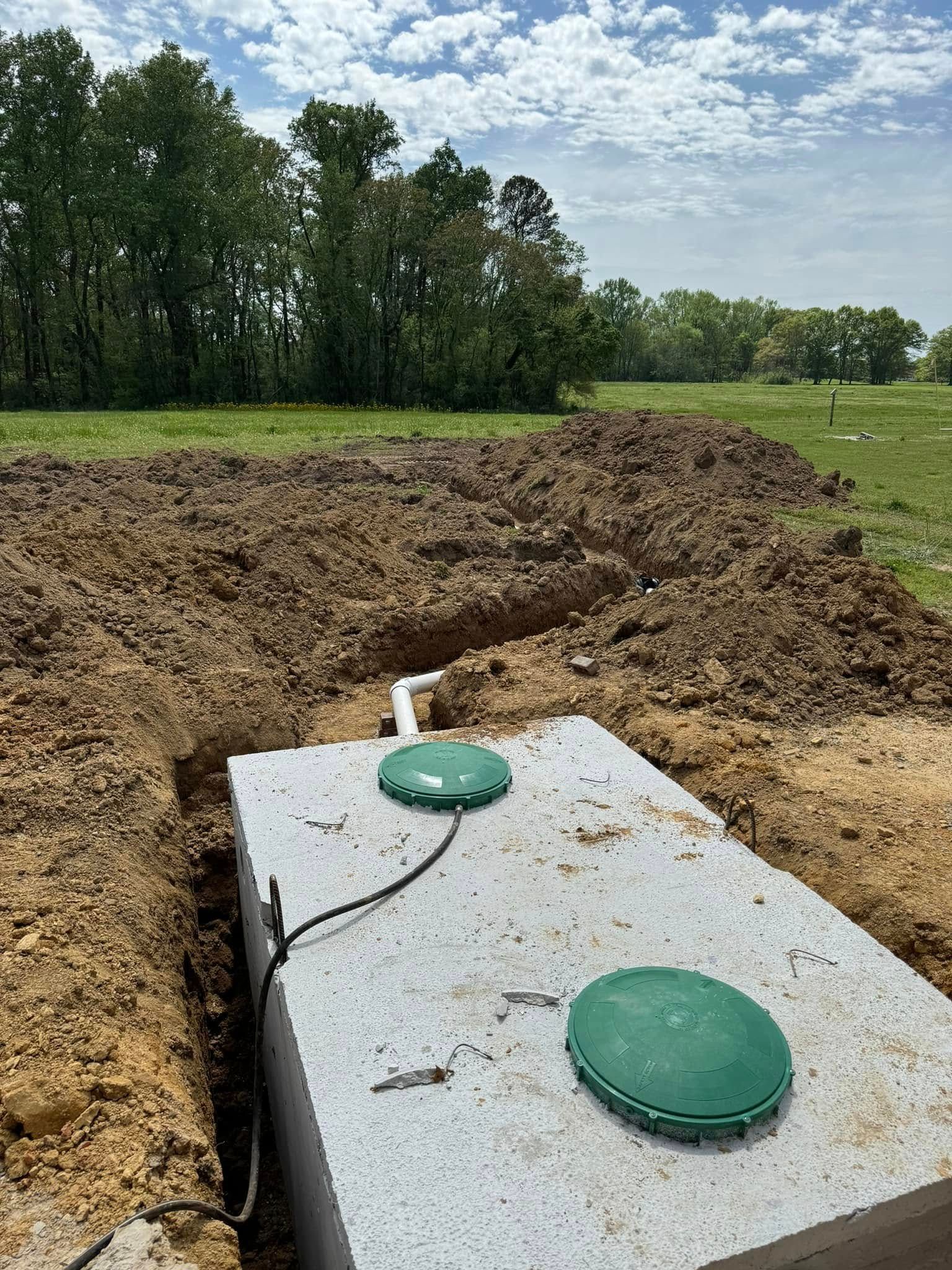 A septic tank is sitting in the middle of a dirt field.