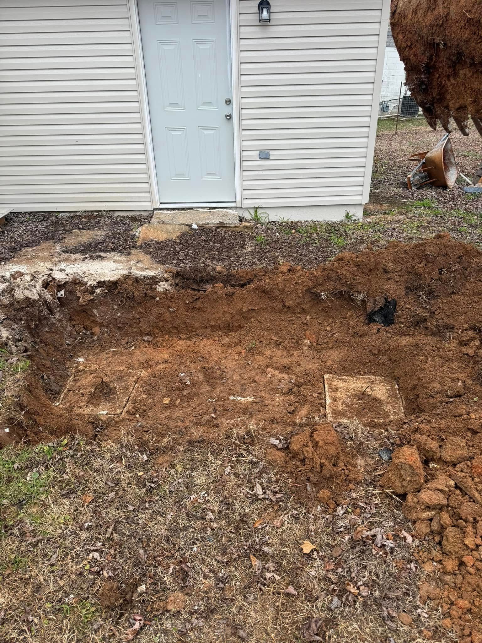 There is a hole in the ground in front of a house.