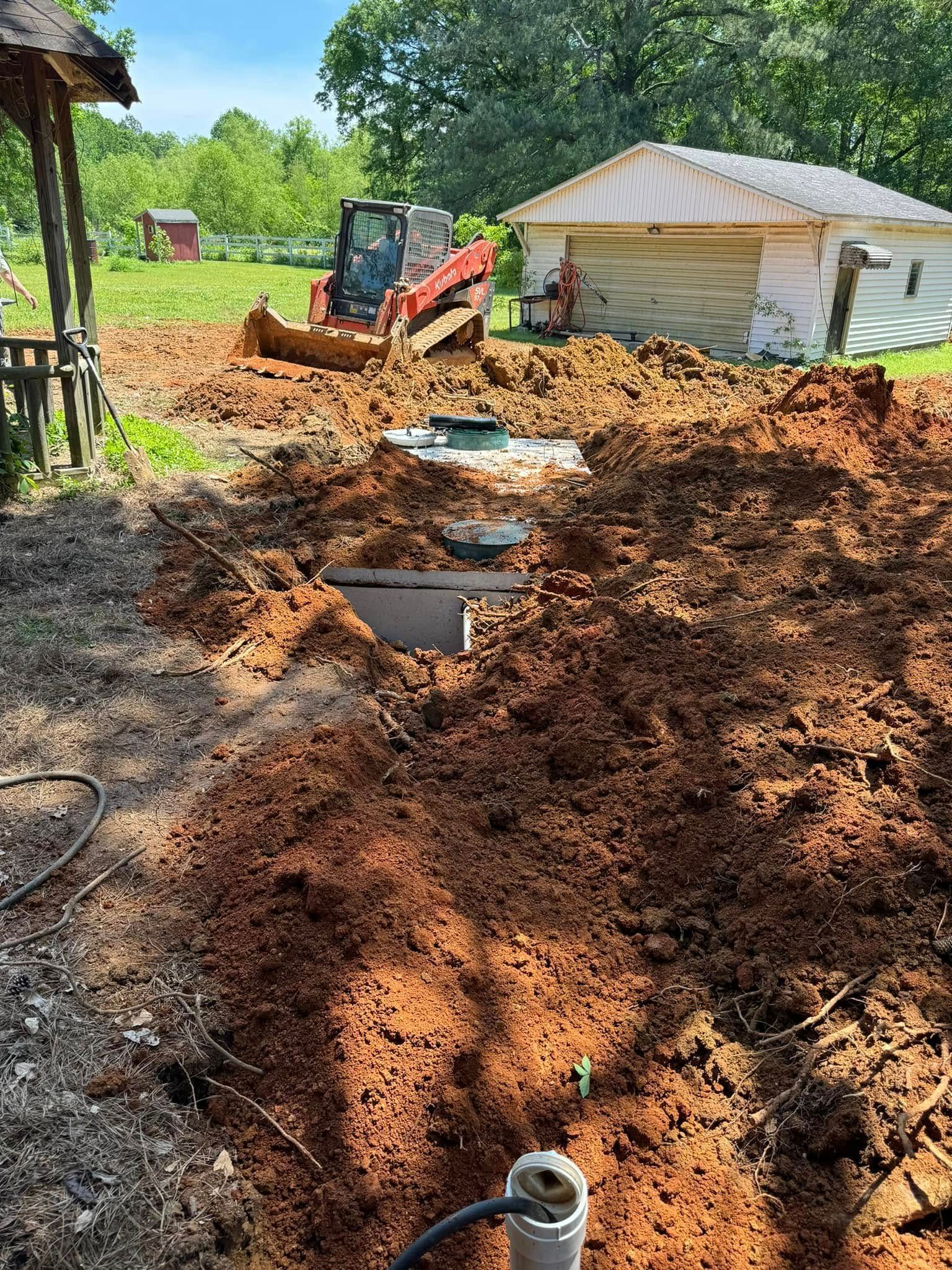 A tractor is digging a hole in the dirt in front of a house.