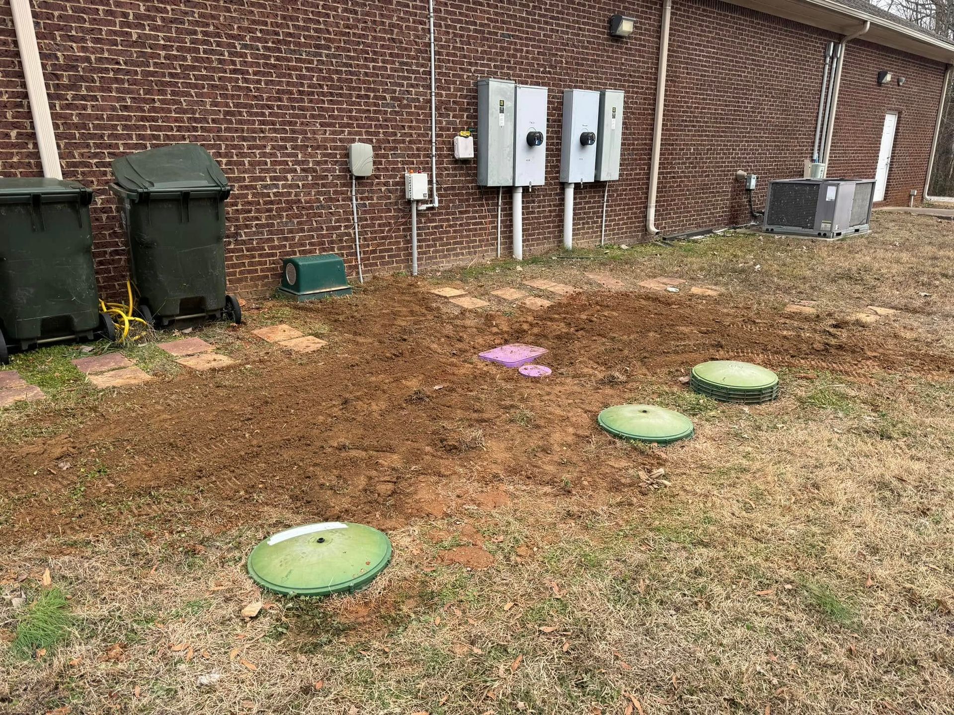 A brick building with a lot of trash cans in front of it.