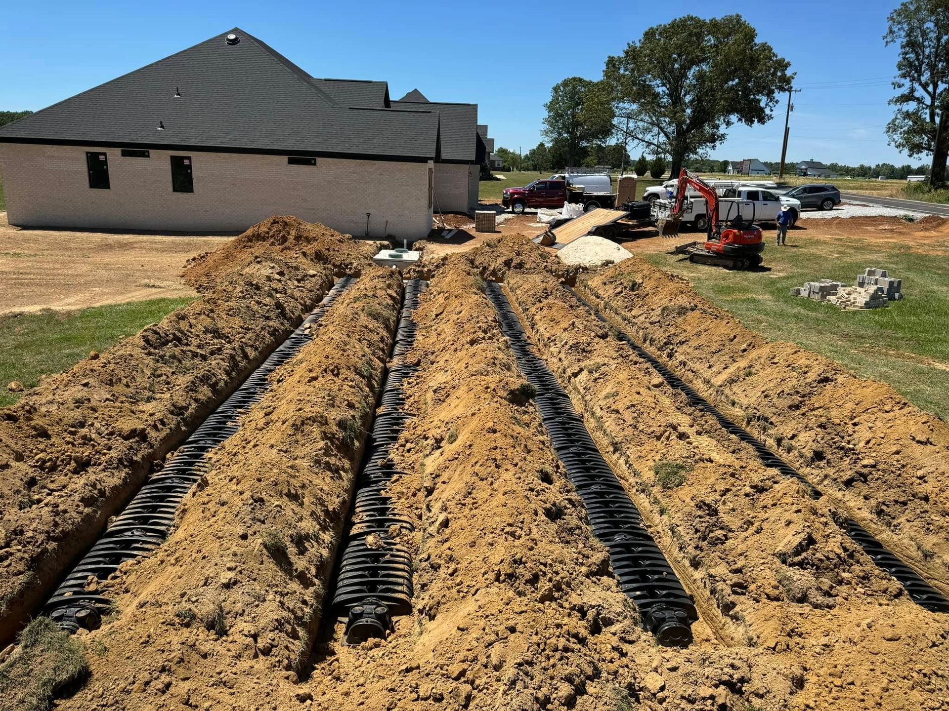 A large pile of dirt with a house in the background