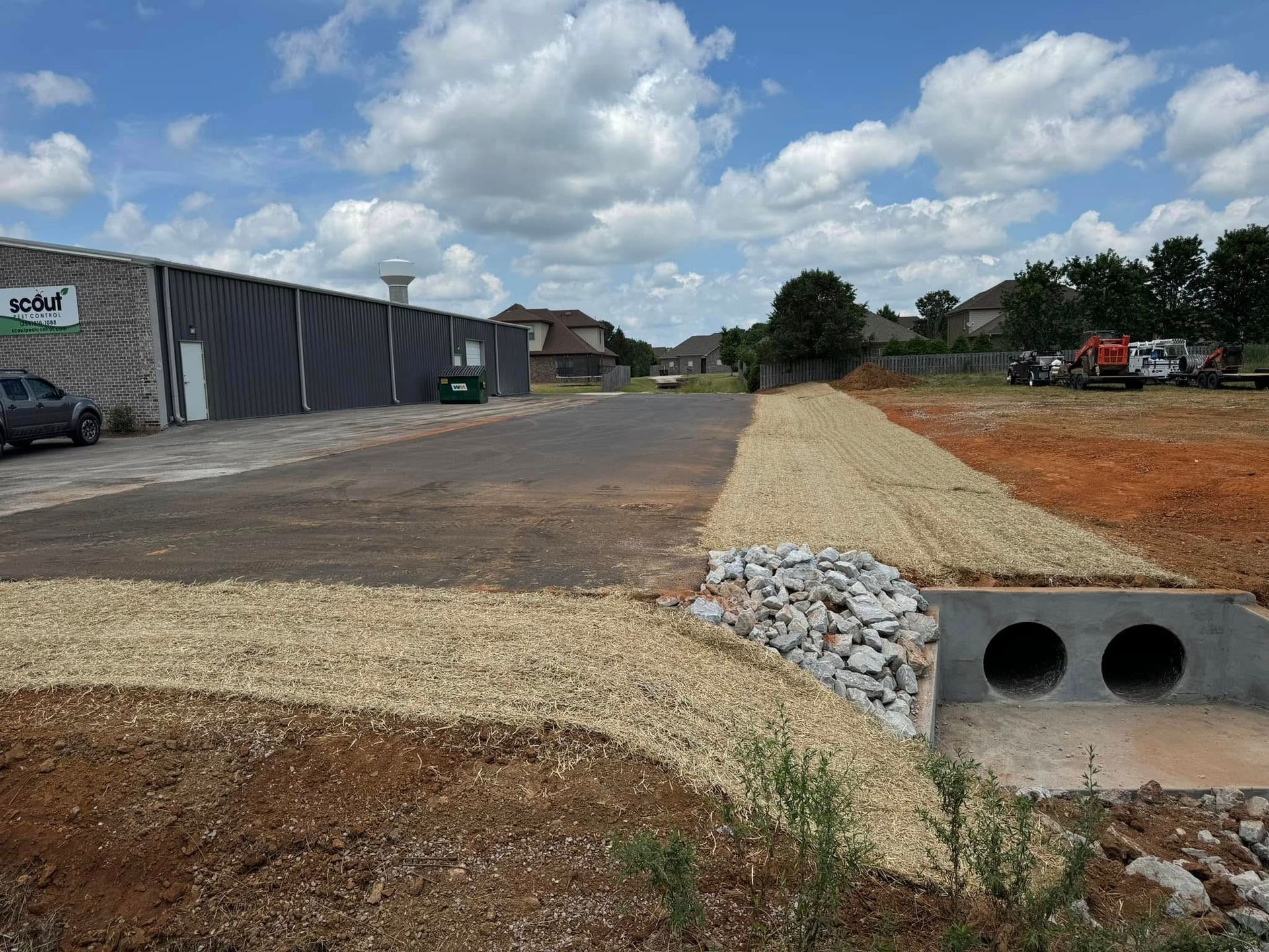 A large building with a water tower in the background is being built.
