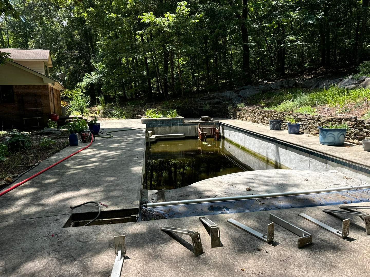 A swimming pool is being remodeled in the backyard of a house.