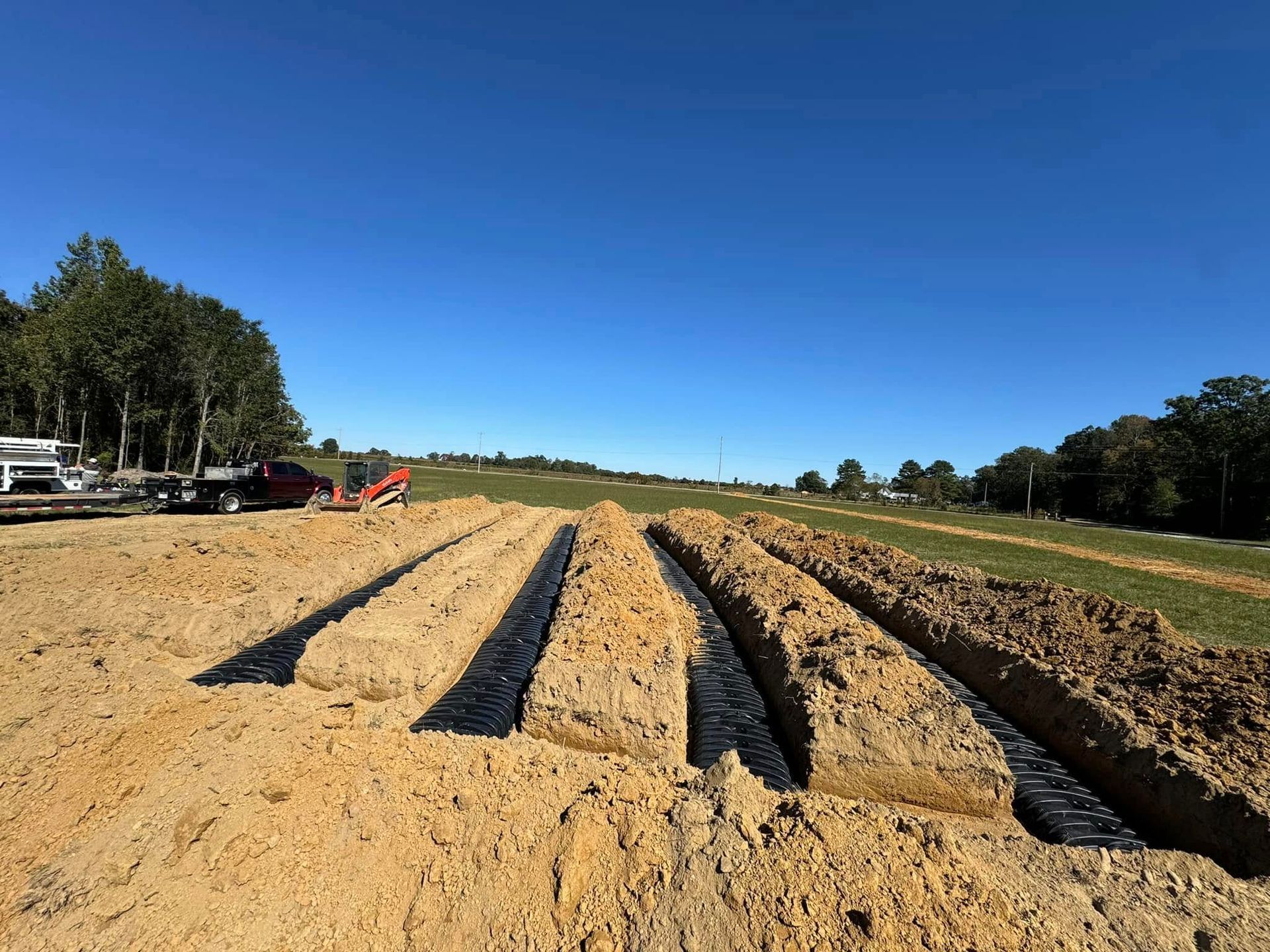 A dirt field with a truck parked in the background.