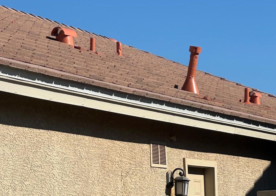 The roof of a house has a lot of chimneys on it