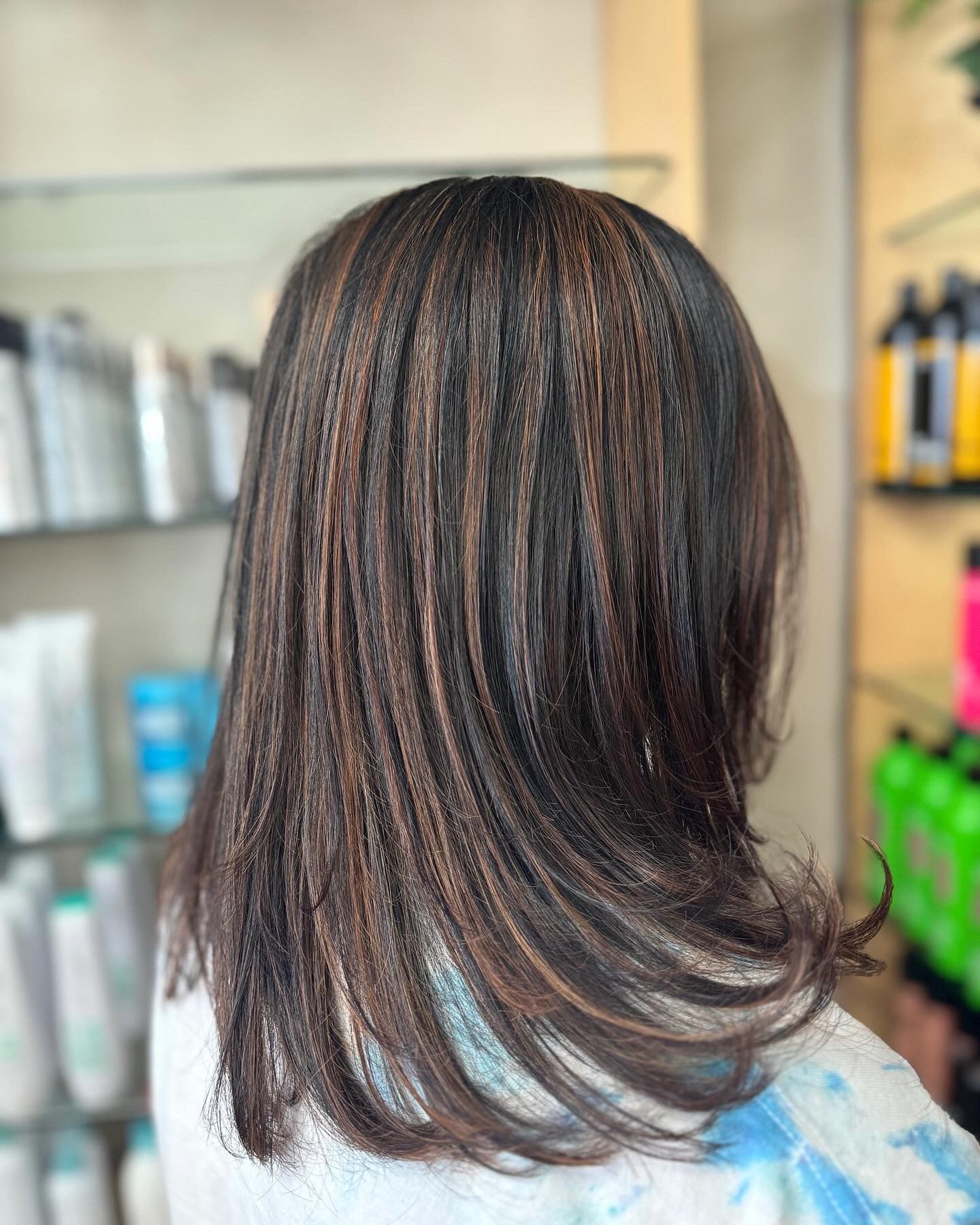 The back of a woman 's hair is shown in a salon.