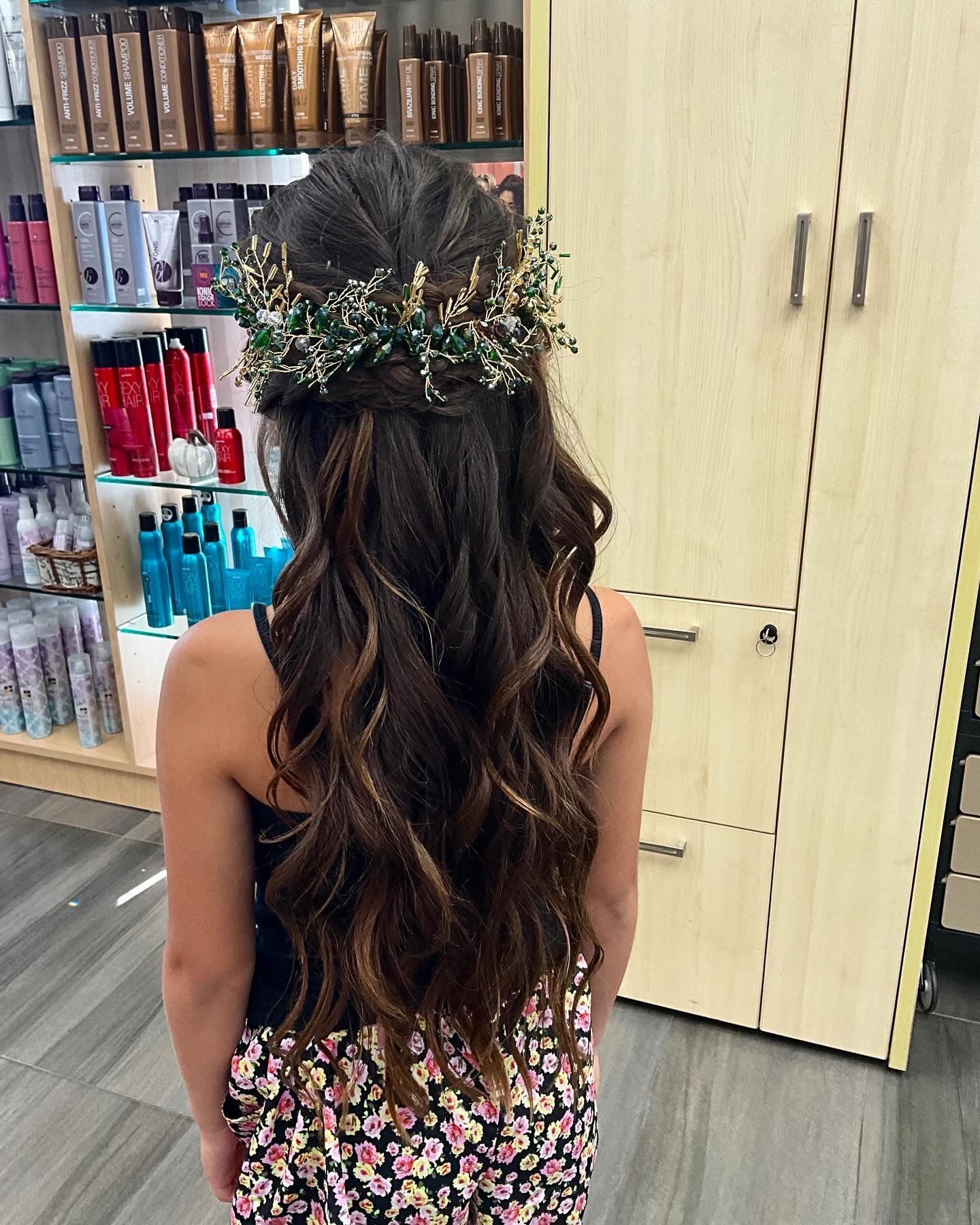 A woman with long hair is wearing a flower crown in her hair.