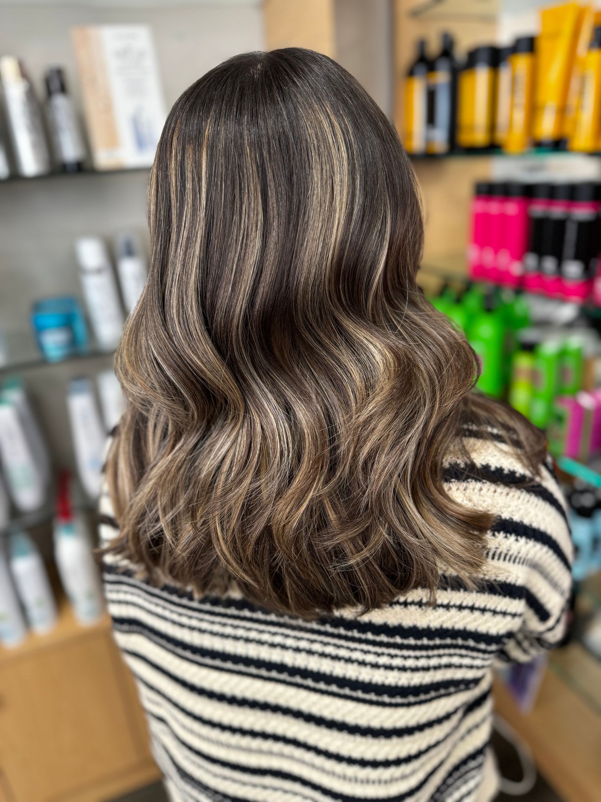 The woman is wearing a striped sweater and has long hair.