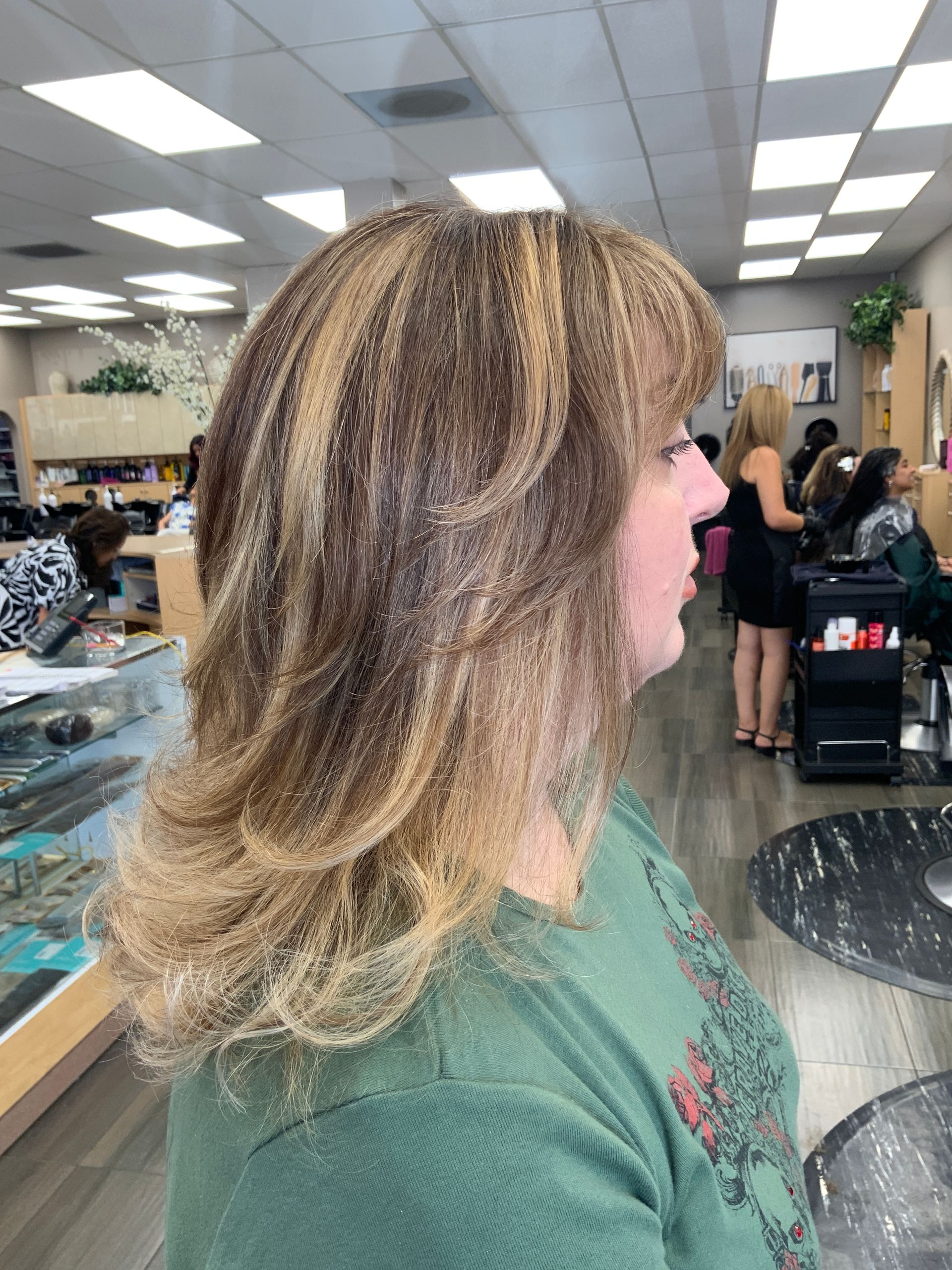 A woman is getting her hair cut in a salon.