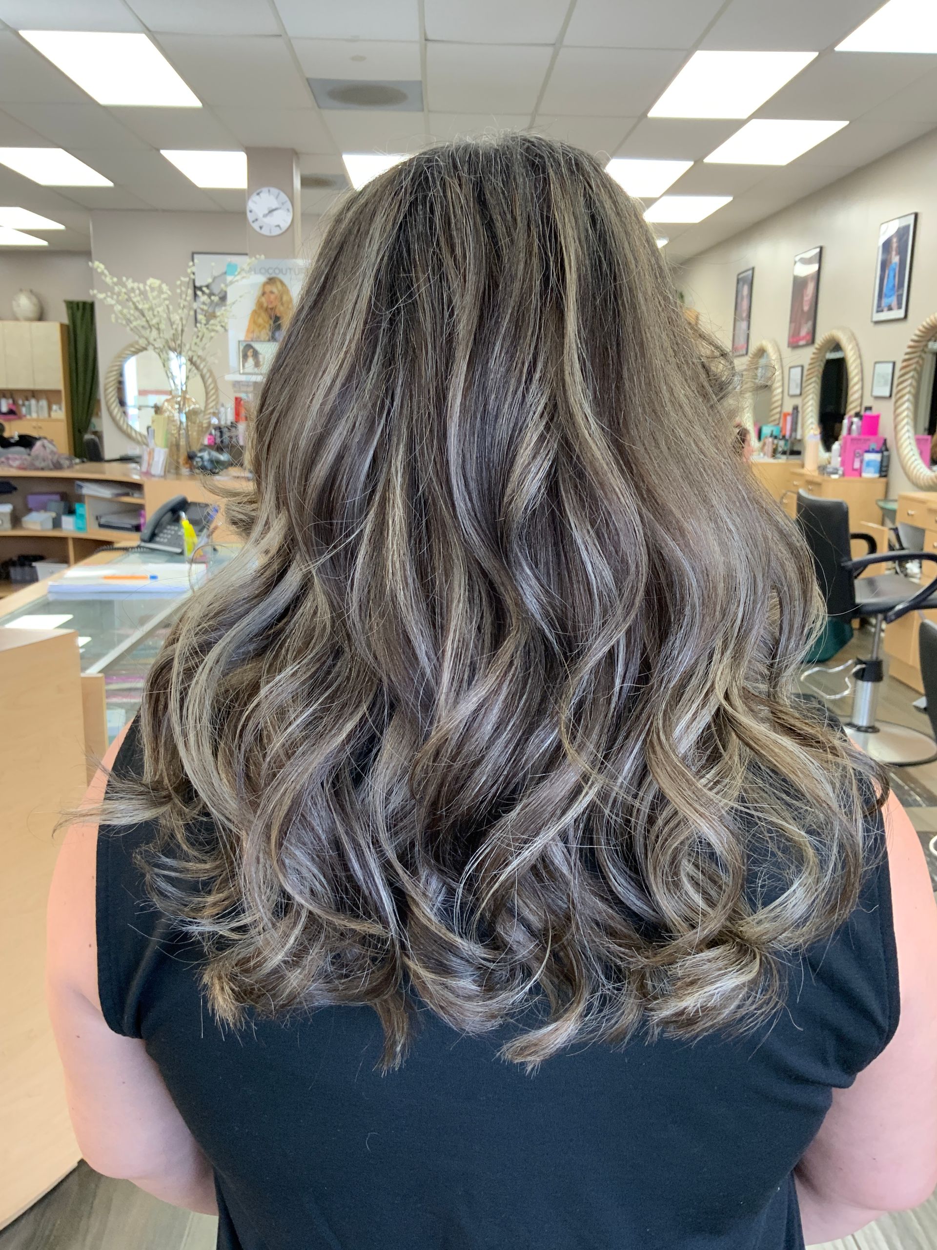 The back of a woman 's hair is shown in a salon.
