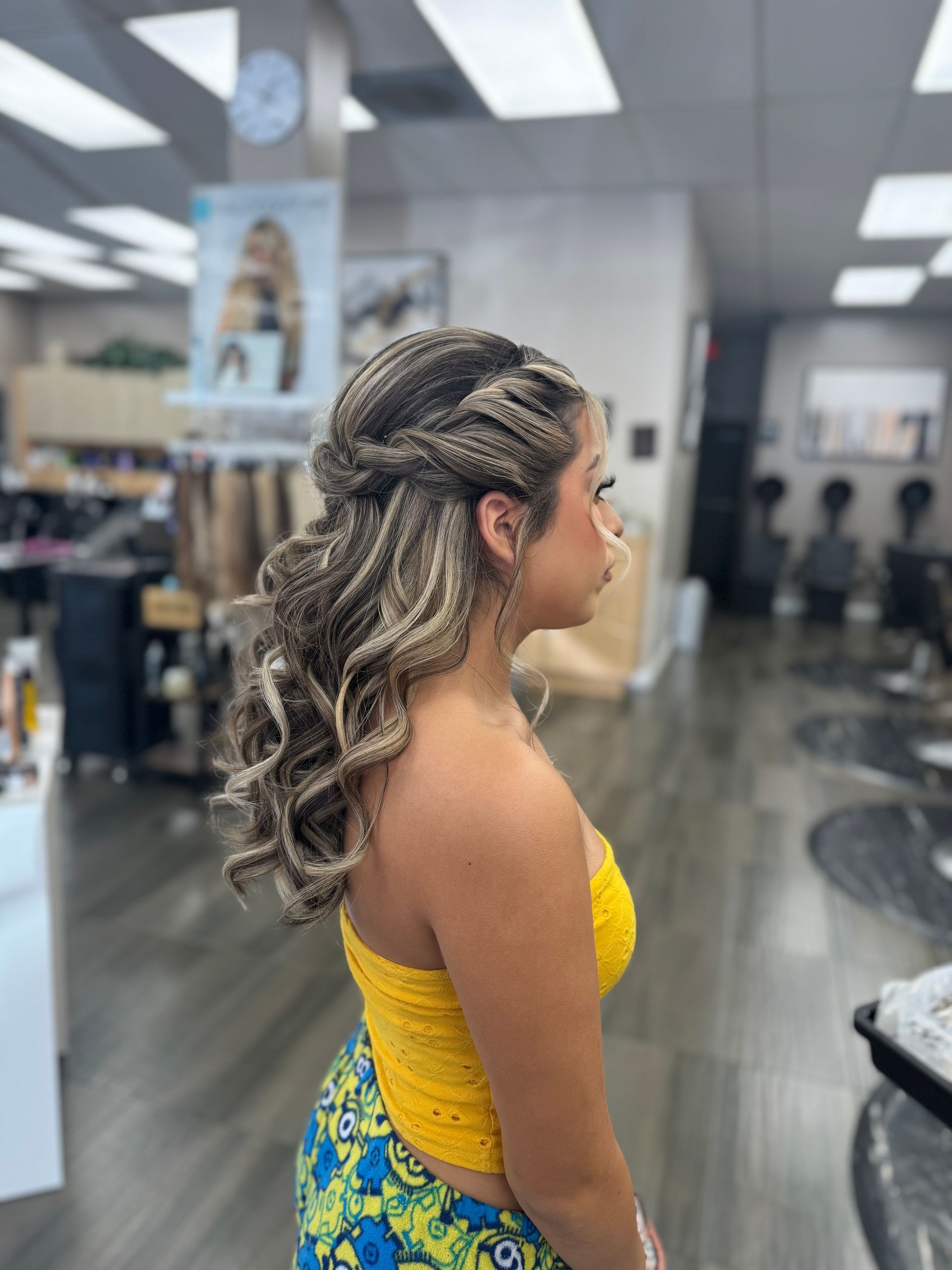 A woman is getting her hair braided in a salon.