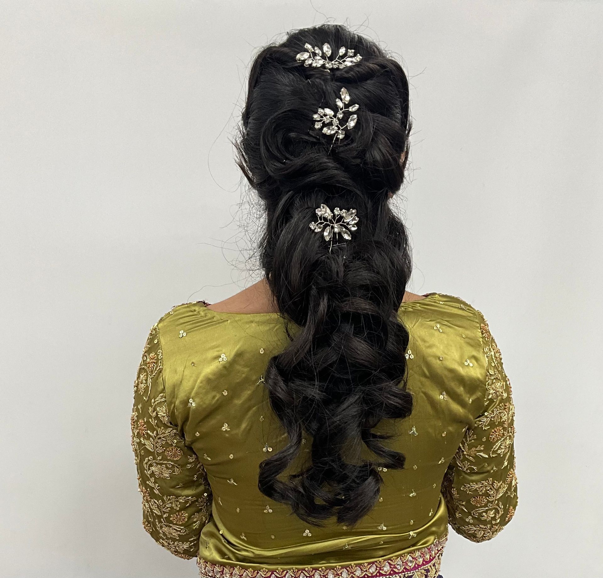 The back of a woman 's head with her hair in a ponytail.