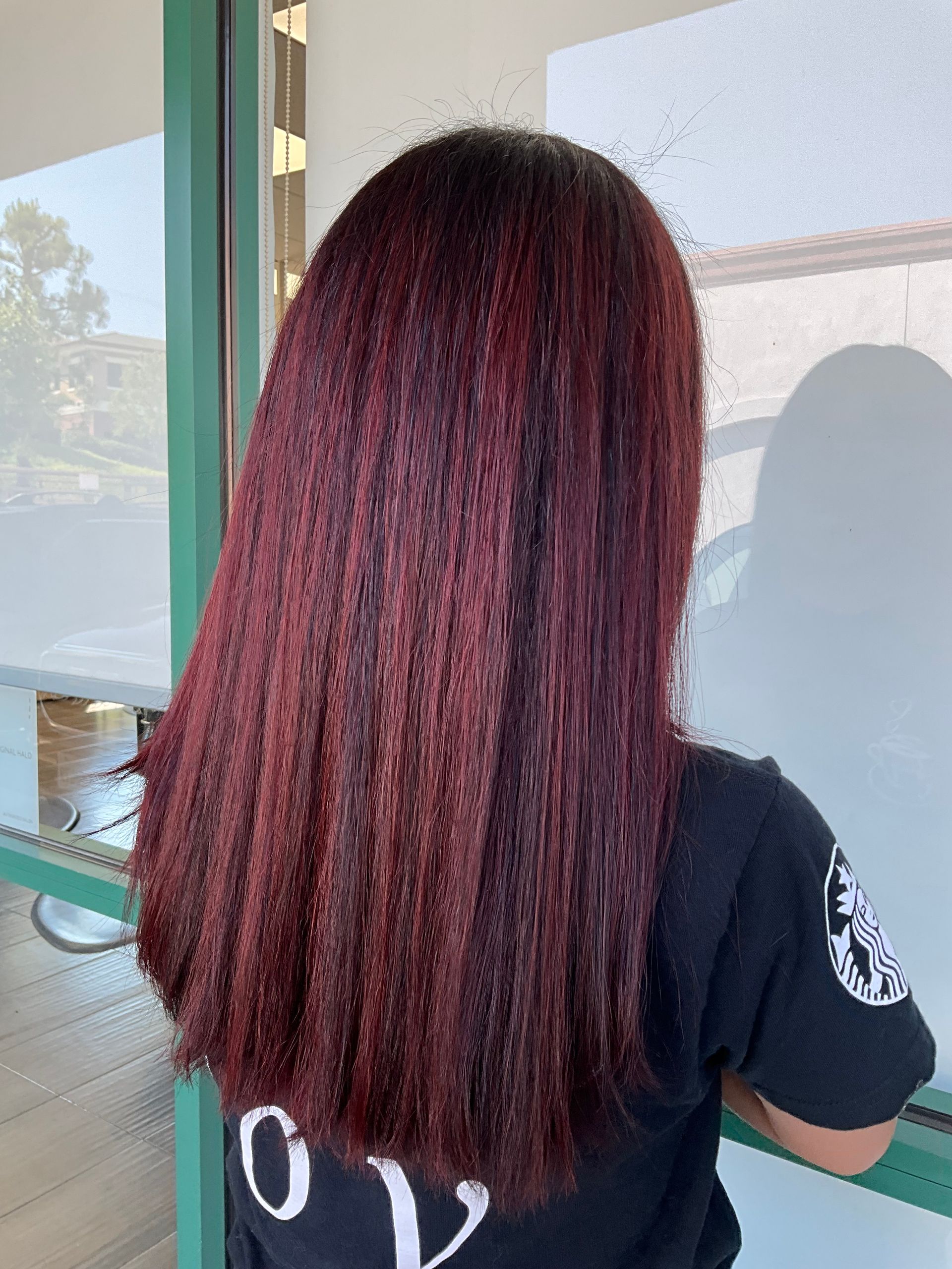 A woman with long red hair is wearing a black shirt.
