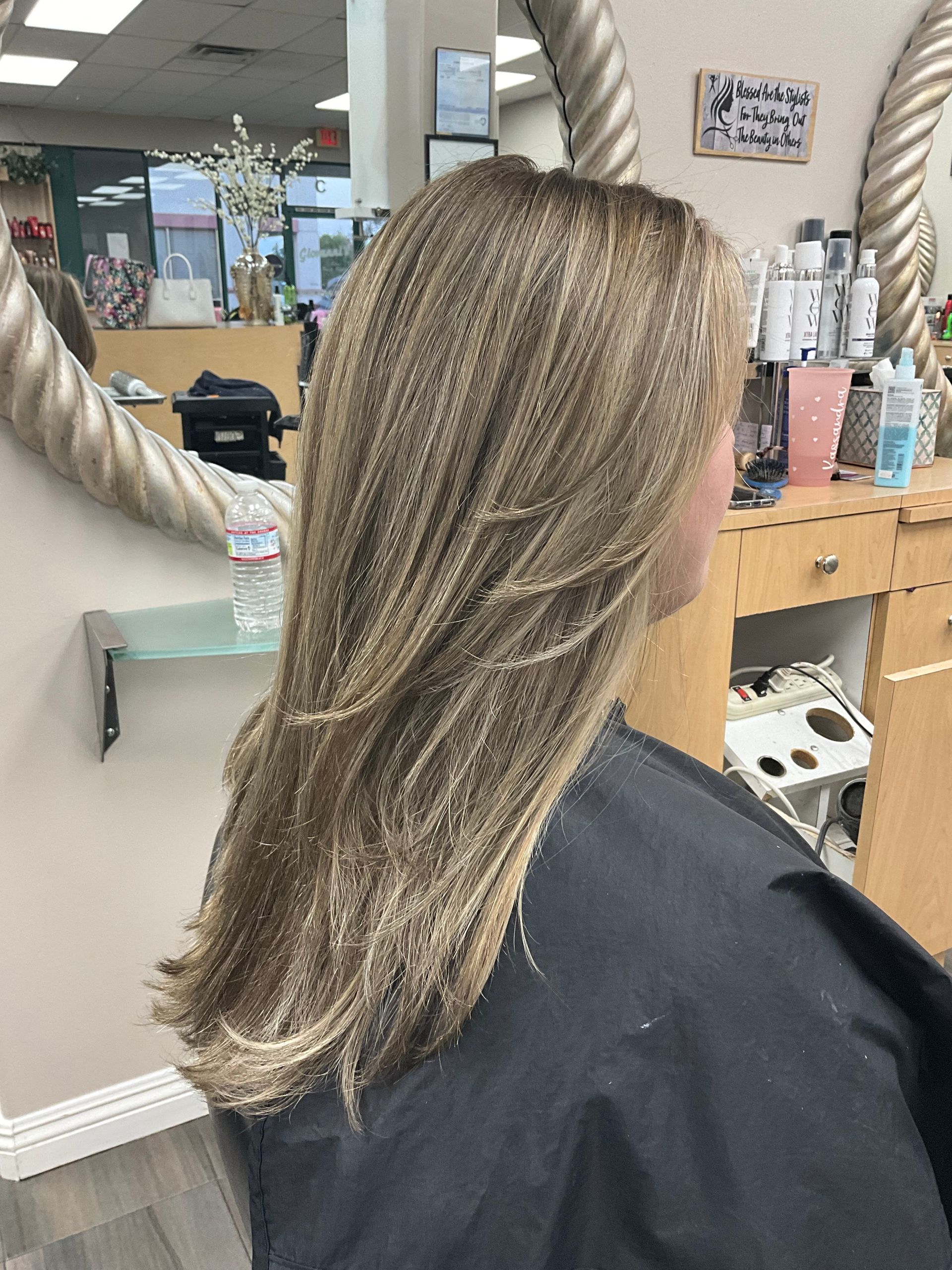 A woman is getting her hair cut in a salon.
