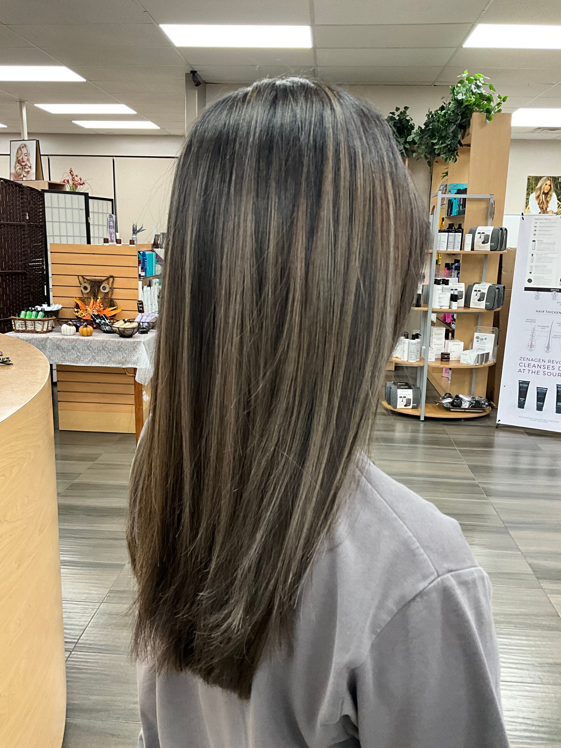 A woman with long hair is standing in a salon.