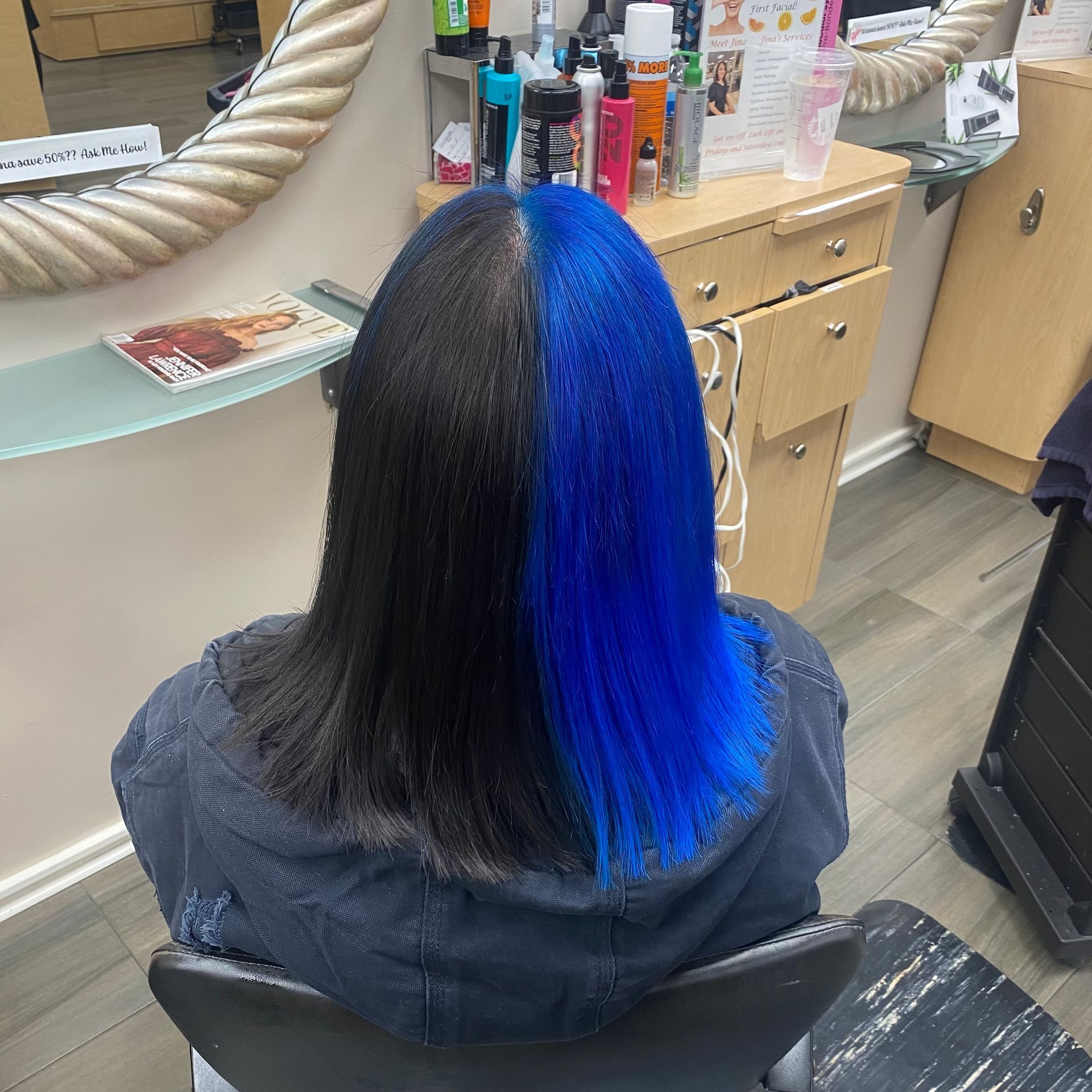 A woman with blue hair is sitting in a chair