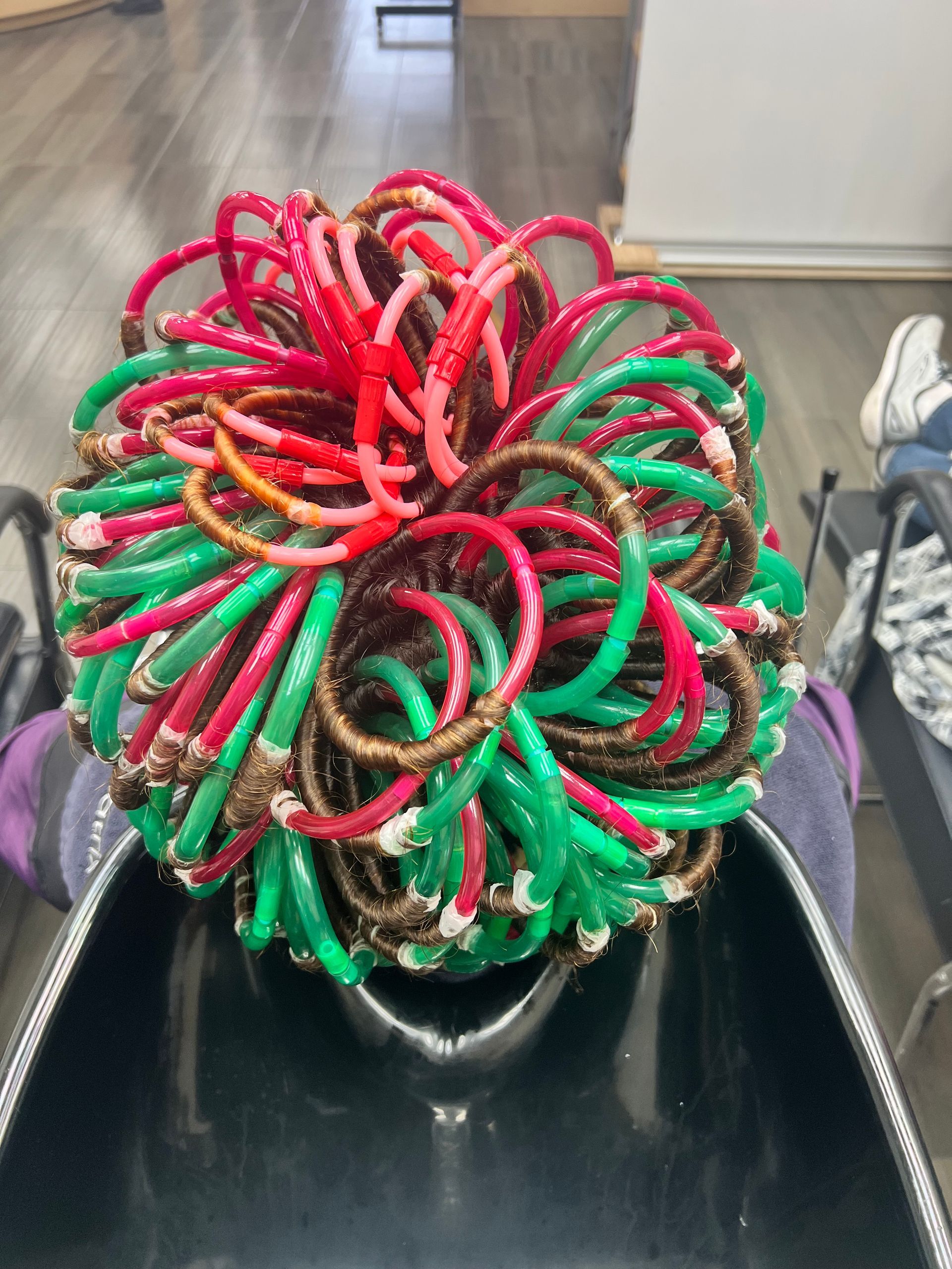 A bunch of colorful rubber bands on a person 's head