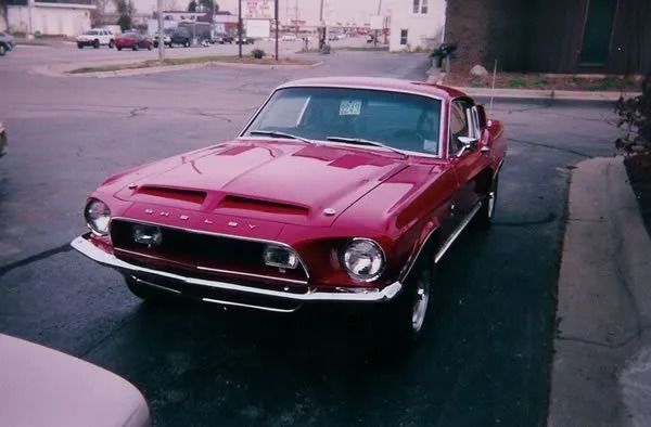 Red 1967 Ford Mustang Shelby GT500 parked in a parking lot.