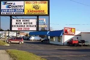 Car repair shop with multiple signs, including