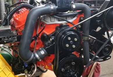 Orange engine with black components, belts, hoses.