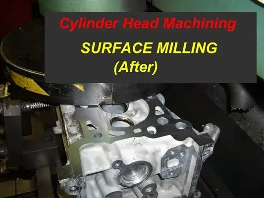 Cylinder head being surface milled by a machine, close-up view. After the process. Black and silver machinery.