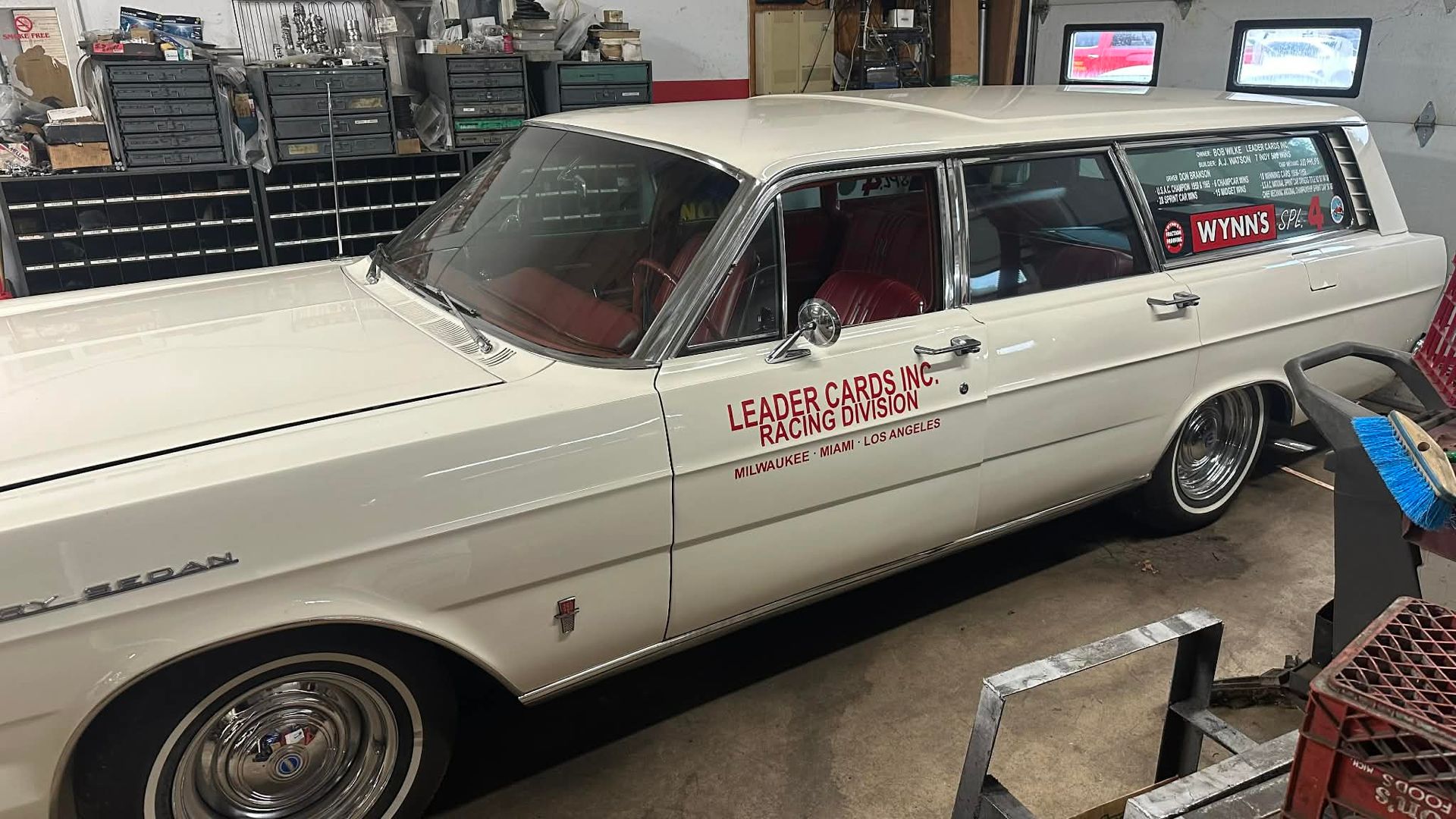 White Ford station wagon with red interior, side text 