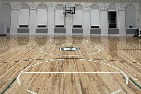 A basketball court with a wooden floor and a logo on it